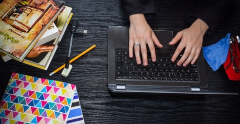 Student typing at laptop