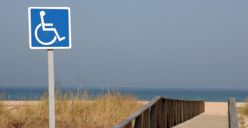 Accessible path to a beach with a wheelchair sign