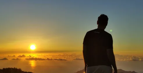 Adrien, wearing an Annertech tshirt, looking at the sun set