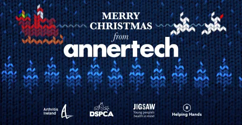 The background is a cross-stitch style image of Santa’s sleigh flying over a forest. The text says Merry Christmas from Annertech, and the logos of Arthritis Ireland, DSPCA, Jigsaw and Helping Hands are at the bottom of the image.