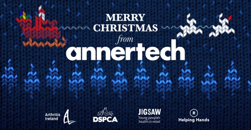 The background is a cross-stitch style image of Santa’s sleigh flying over a forest. The text says Merry Christmas from Annertech, and the logos of Arthritis Ireland, DSPCA, Jigsaw and Helping Hands are at the bottom of the image.