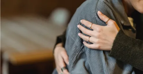 A person is comforted with a hug