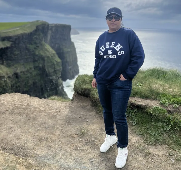 Sana Ather poses with the Cliffs of Moher in the background.