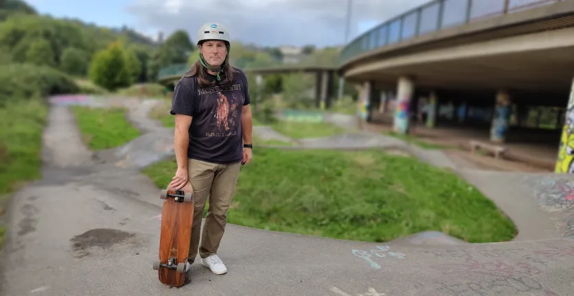Simon White shows off his skateboard at a park near his home.