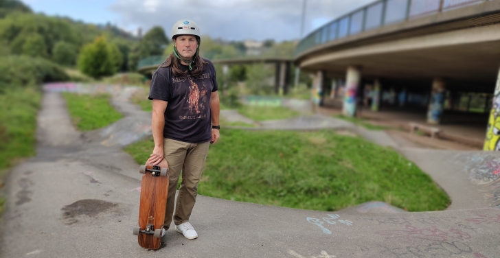 Simon White shows off his skateboard at a park near his home.