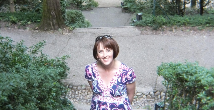 Claire O'Brien pauses for a photo on steps surrounded by trees in Lyon.