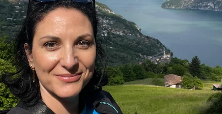 Alina Basarabeanu takes a selfie while on holiday. The background is some mountains and a river.