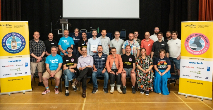 A group of LocalGov Drupal Camp organisers and participants pose next to two LocalGov Drupal banners.