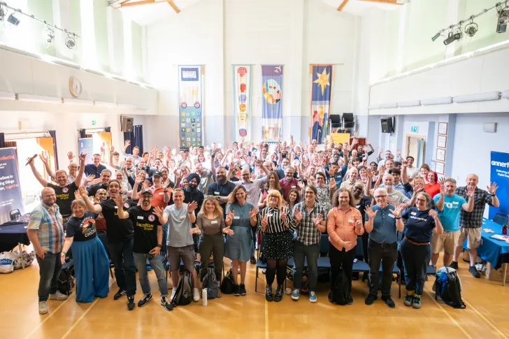 A group of people wave for the photographer.