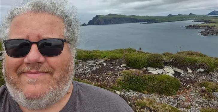 Dermot takes a selfie with the sea in the background.