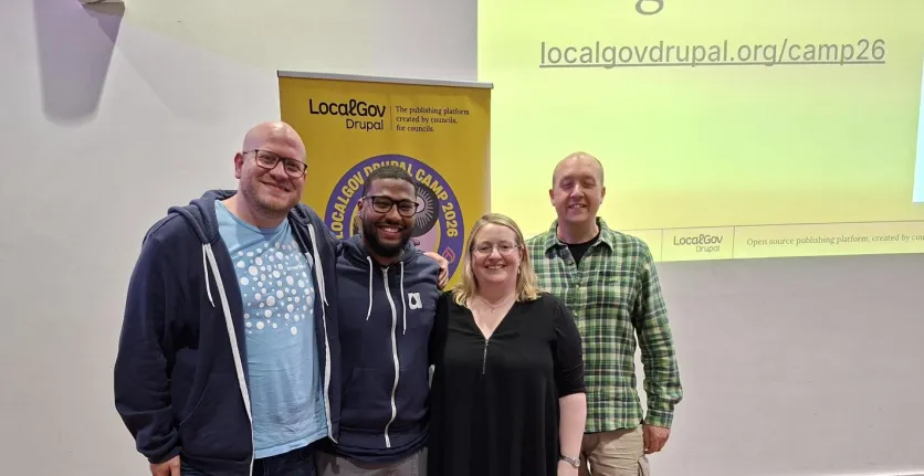 Four members of Team Annertech stand in front of a LocalGov Drupal banner.
