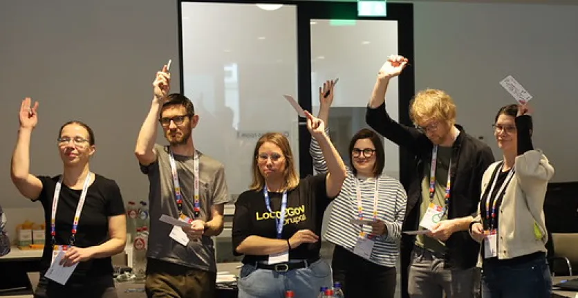 Government summit attendees raise their hands during a fun activity.