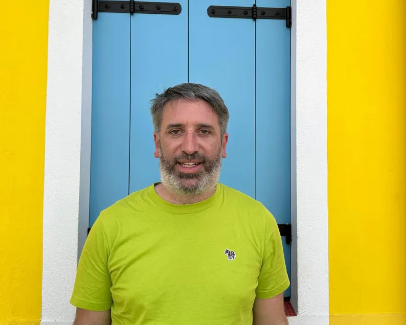 Tony Barker stands in front of a blue door.