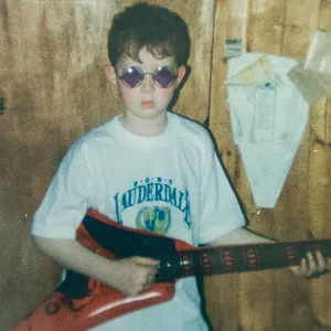 A young Martin holds an electric guitar