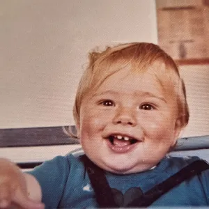 Baby Anthony Lindsay in a high chair.