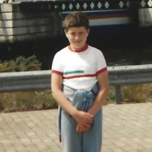 A young Dermot Frost poses in front of a ferry.