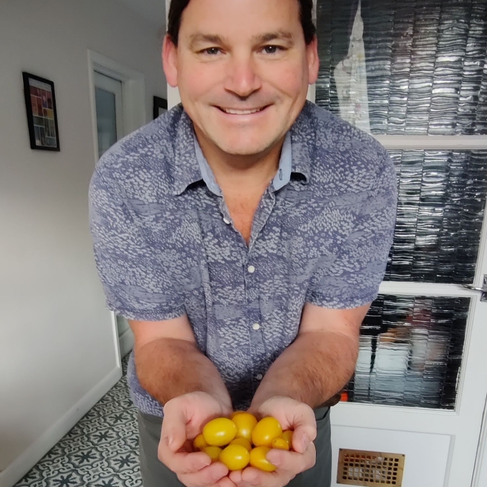 Simon shows off a tomato crop