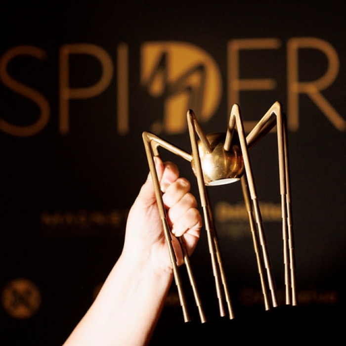A Spider award is held aloft.