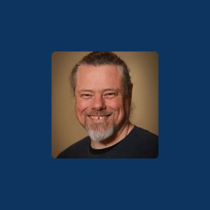 A head-and-shoulders image of Anthony Lindsay on a dark blue background