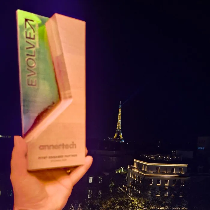 The Evolve trophy is held aloft with the Eiffel Tower in the background.