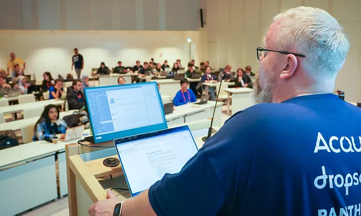 A full lecture hall, with a lecturer presenting on Drupal in a Day