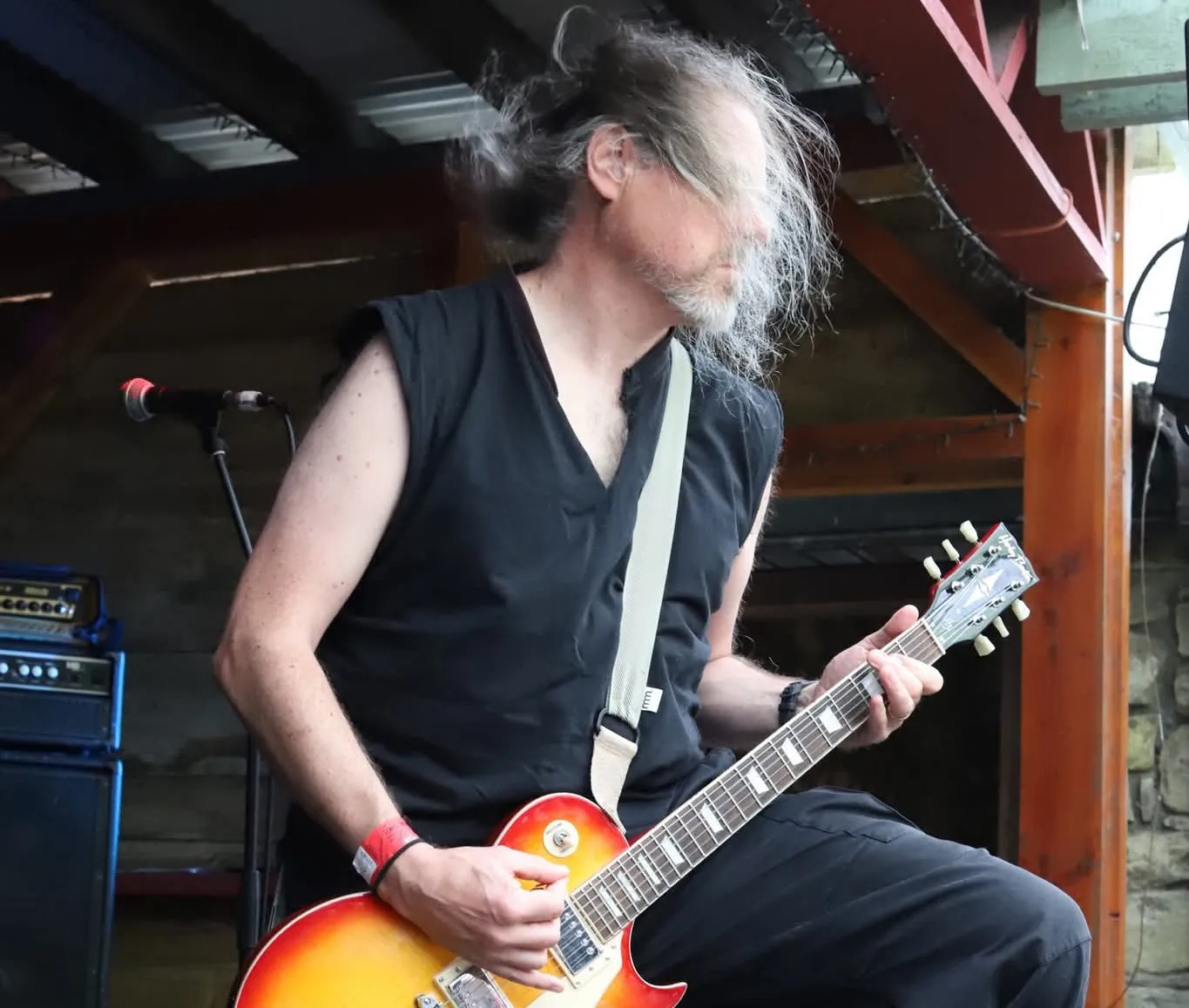 Anthony Lindsay wielding a guitar on stage.