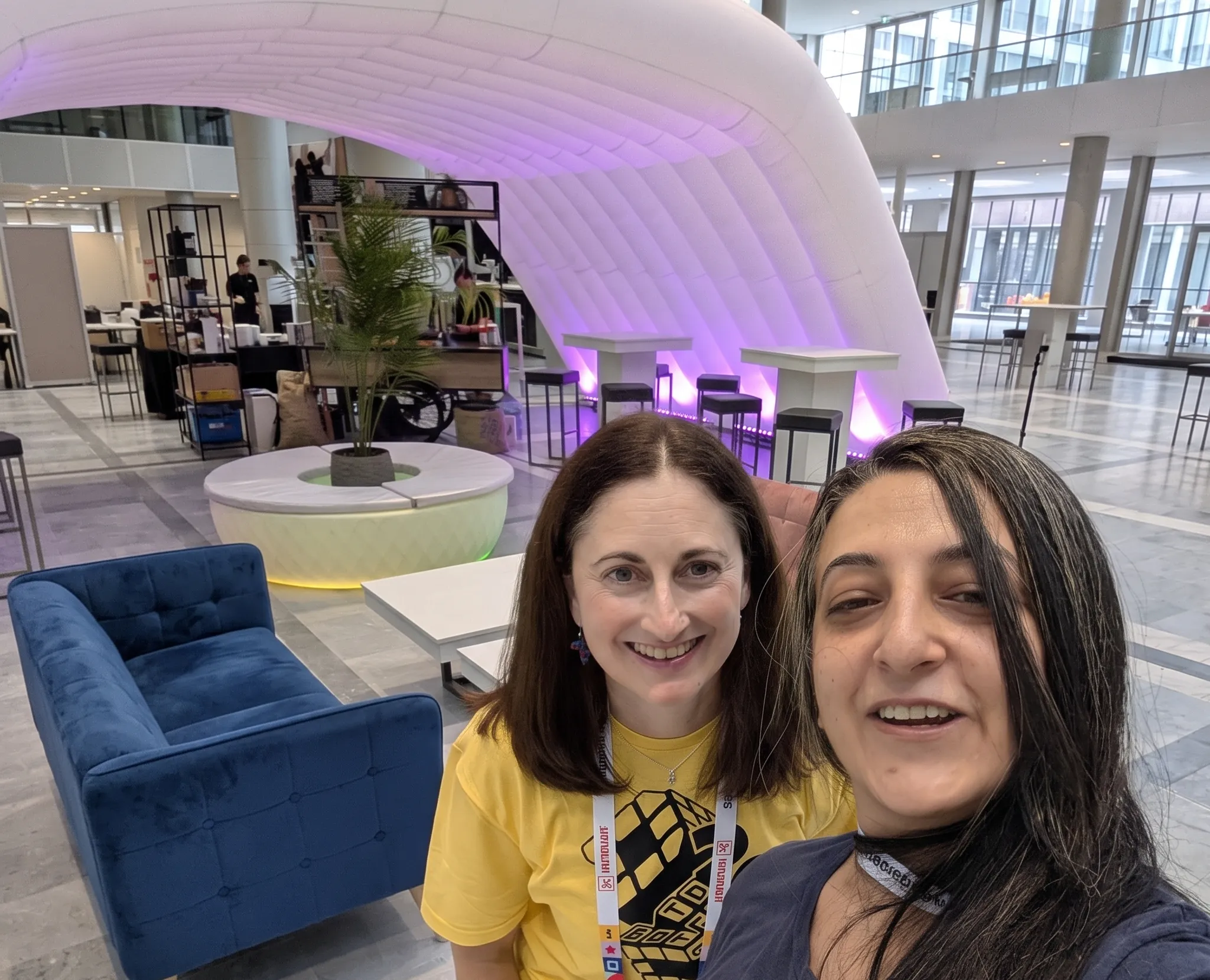 Alison and Layal take selfie in front of the DrupalJam booth.